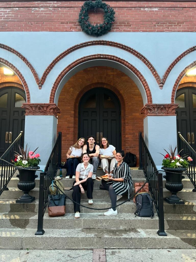 Wavy team sitting on stairs in front of an old building.